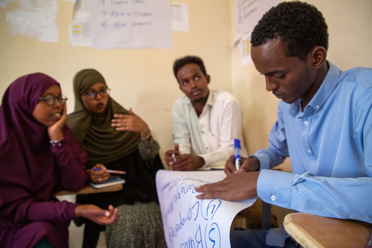 A young man explaining his idea to his group